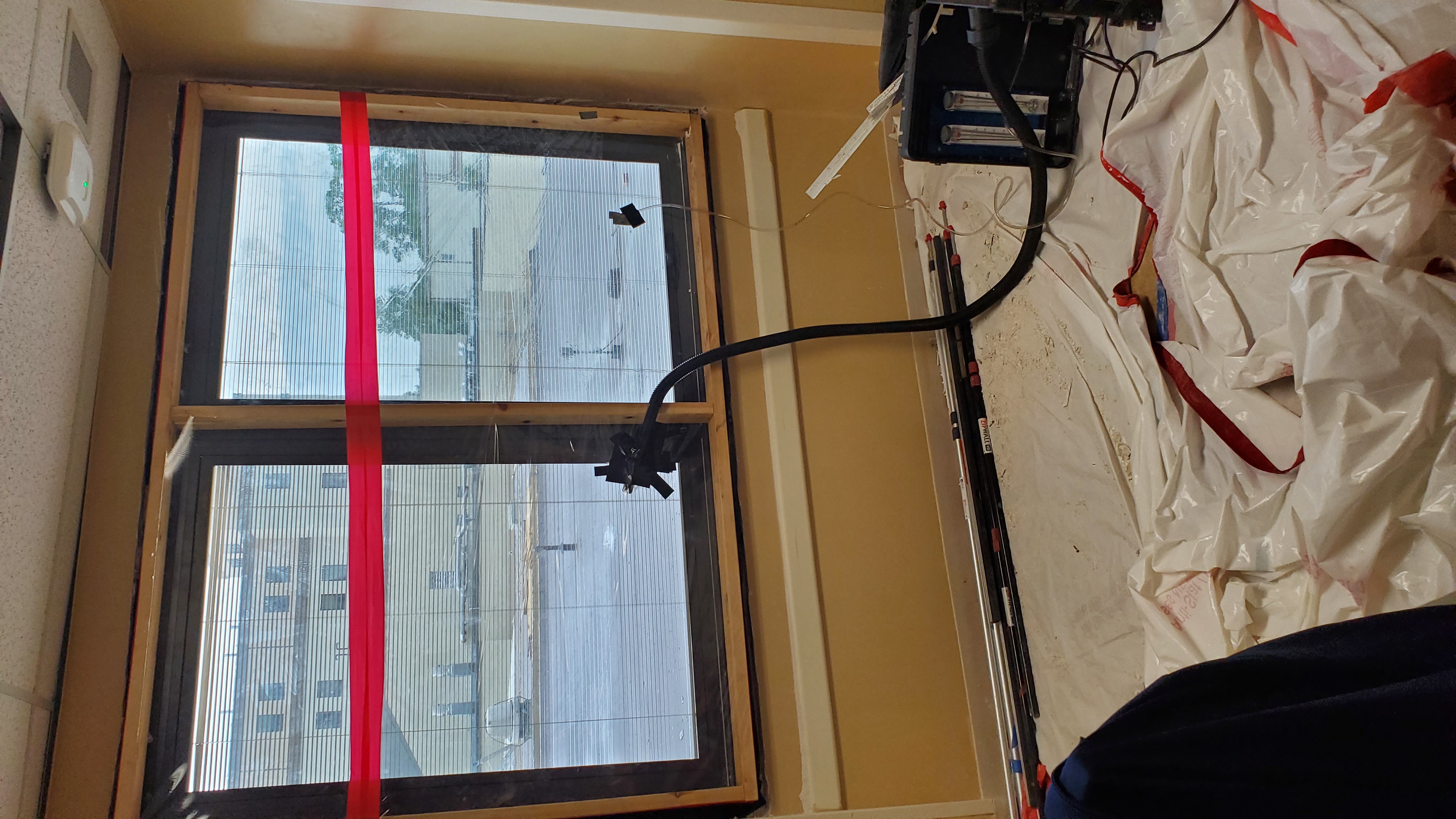 Interior AAMA window water test with spray hose and pressure monitoring equipment